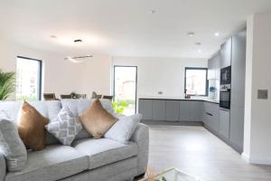 een woonkamer met een bank en een keuken bij Stunning 2 Bedroom Apartment - 5 mins walk to center in Belfast