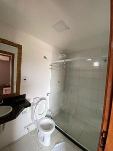 uma casa de banho com um chuveiro, um WC e um lavatório. em Serra Negra Pousada Spa em Guarapari