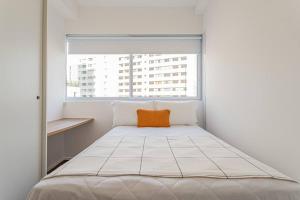 Cama en habitación blanca con ventana en Apt. inteiro recém-reformado - Vila Madalena, en São Paulo