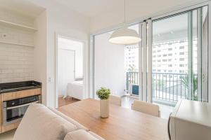 cocina y comedor con mesa y ventana grande en Apt. inteiro recém-reformado - Vila Madalena, en São Paulo