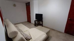 sala de estar con sofá y TV en Apartamento amoblado a excelente precio, en Bogotá
