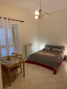 een slaapkamer met een bed en een tafel. bij Casa Marconi 3, centrale, parking gratuit en rue. in Aragona