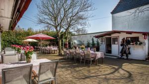 a patio with tables and chairs and a building at The Little Britain Inn Themed Hotel One of a Kind In Europe in Vettelschoß