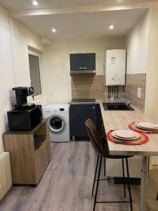 a kitchen with a table and a washing machine at Appartement F2 meublé in Dunkerque