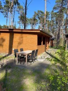 een tafel en stoelen voor een hut bij Domek Dębowy 2 in Lubniewice