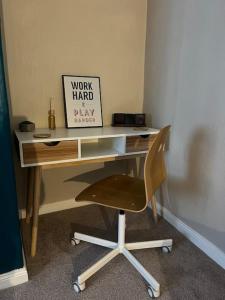 a desk with a chair and a sign on it at Stylish & Centrally Located in Chester-le-Street