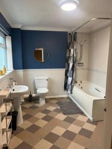 a bathroom with a toilet and a tub and a sink at Stylish & Centrally Located in Chester-le-Street