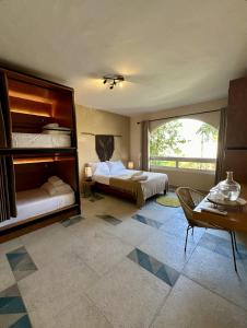坎昆的住宿－Pachamaya - Suites, Wellness & Spa, Retreats，大房间设有两张床、一张桌子和一张沙发