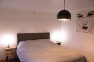 1 dormitorio con 1 cama con 2 mesitas de noche y 2 lámparas en Vakantiewoning 't Bruggeneindje, en Heist-op-den-Berg