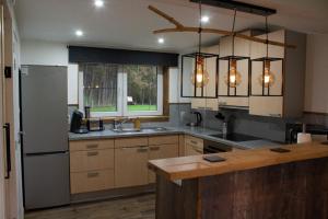 a kitchen with a sink and a refrigerator at Vakantiewoning 't Bruggeneindje in Heist-op-den-Berg
