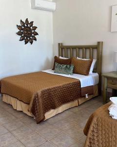a bedroom with a bed and a clock on the wall at Costa del Sol Hotel & Sportfishing in Bahía de los Ángeles