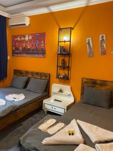 two beds in a room with an orange wall at Taksim Pandora hotel in Istanbul