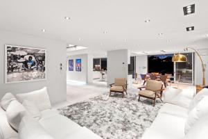 a white living room with a white couch and chairs at Hollywood Hills Luxury Modern Home with Pool & Sunset views in Los Angeles