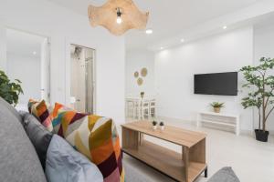 ein Wohnzimmer mit einem Sofa und einem Couchtisch in der Unterkunft Suite Homes Hesperides 914 in Málaga