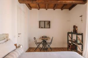 a bedroom with a bed and a table with chairs at B&B Giarola 25.2 in Cittanova