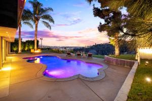 una piscina en un patio trasero con palmeras en Hollywood Hills Luxury Modern Home with Pool & Sunset views, en Los Ángeles