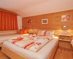 a large bed in a room with wooden walls at Ferienhaus Frühlingsheim in Sölden