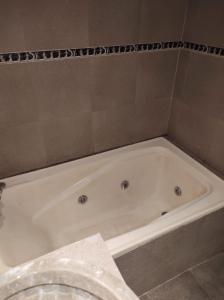 a white bath tub in a bathroom at Dakini Hostel in Lomas de Zamora