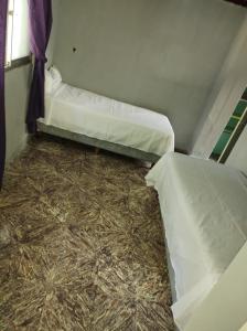 two beds in a small room with hay at Dakini Hostel in Lomas de Zamora