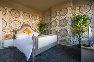 ein Schlafzimmer mit einem Bett und einer Wand mit Pflanzen in der Unterkunft Stunnning 4 Bed House Hot Tub Sky Tv Pool Table in London