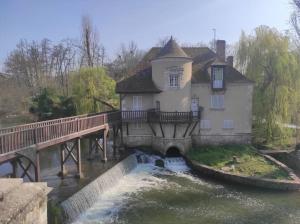 a house on a bridge over a river at Gîte les petites bruyères in Veneux-les-Sablons