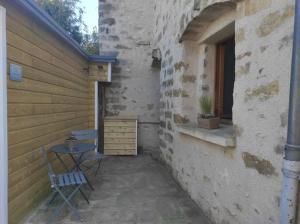 a patio with a table and a chair next to a building at Gîte les petites bruyères in Veneux-les-Sablons