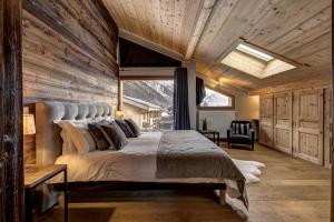 a bedroom with a large bed with a wooden wall at Chalet Planards 1 in Chamonix-Mont-Blanc