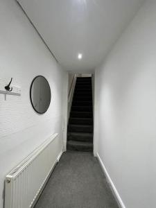 a hallway with a staircase with a mirror and a stair case at 212a bell lane in Bury