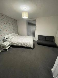 a bedroom with a bed and a couch at 212a bell lane in Bury