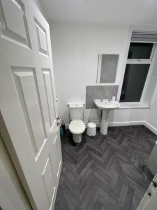 a white bathroom with a toilet and a sink at 212a bell lane in Bury