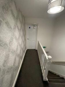 a hallway with a staircase with a white wall at 212a bell lane in Bury