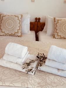 una pila de toallas sentadas encima de una cama en Studios Fokia Beach en Amoopi