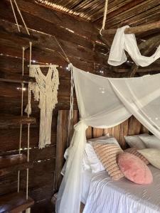 a bedroom with a bed with a mosquito net at wellgaya ecovillas in Villa Flor