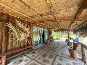 wellgaya ecovillas في Villa Flor: غرفة بجدار خشبي مع طاولة وكراسي