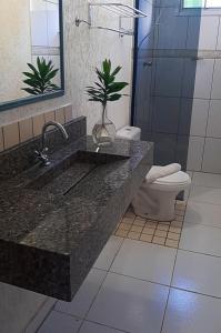 a bathroom with a sink and a toilet at Skalla Hotel Nova Odessa in Nova Odessa