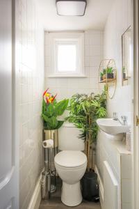 a bathroom with a toilet and plants in it at Stunnning 4 Bed House Hot Tub Sky Tv Pool Table in London