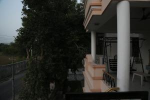 a balcony of a house with a tree on it at Raaga Home in Udaipur