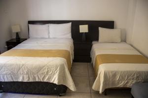 two beds in a hotel room with two at Plaza Mayor Lima in Lima