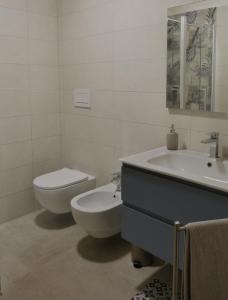 Baño blanco con aseo y lavamanos en Casadoria34 - Appartamento da 70 mq, en Mola di Bari