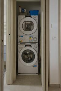 een keuken met een wasmachine en een magnetron bij Casadoria34 - Appartamento da 70 mq in Mola di Bari