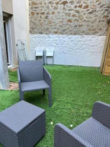 two chairs and a table in a yard with grass at F4 - Duplex spacieux proche d'Orly in Athis-Mons