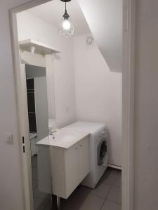 ein weißes Badezimmer mit einer Waschmaschine und einem Waschbecken in der Unterkunft F4 - Duplex spacieux proche d'Orly in Athis-Mons
