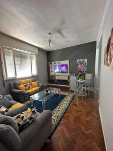 ein Wohnzimmer mit einem Sofa und einem TV in der Unterkunft COPABEACH in Rio de Janeiro