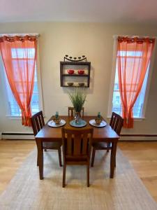 comedor con mesa, sillas y 2 ventanas en Lovely 2-Bed located in Heart of JC!, en Jersey City