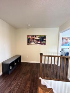 a living room with a couch and wooden floors at Cozy Homestay Waterloo Airport II in Kitchener