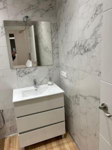 een witte badkamer met een wastafel en een spiegel bij Apartamento Centro de Valladolid CB in Valladolid