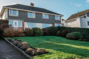 een huis met een tuin met groen gras en struiken bij Ocean City Family Home in Plymouth