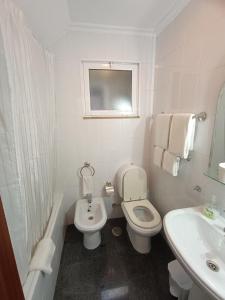 een witte badkamer met een toilet en een wastafel bij Casa 42 in Monção