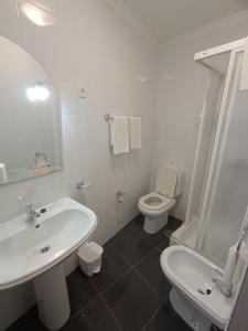een witte badkamer met een wastafel en een toilet bij Casa 42 in Monção