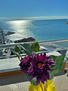 een vaas gevuld met paarse bloemen zittend op een tafel bij NOVA Sea View Apartments in Durrës